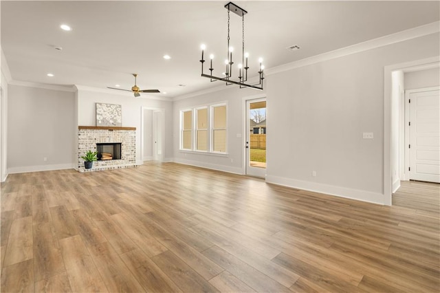 unfurnished living room with crown molding, light wood-style floors, a fireplace, and a ceiling fan