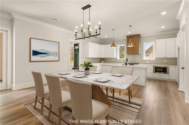 dining room featuring ornamental molding, recessed lighting, light wood-style flooring, and baseboards