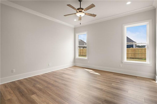 unfurnished room with light wood-type flooring, plenty of natural light, baseboards, and crown molding