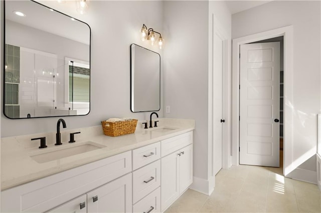 full bath with double vanity, tiled shower, a sink, and tile patterned floors