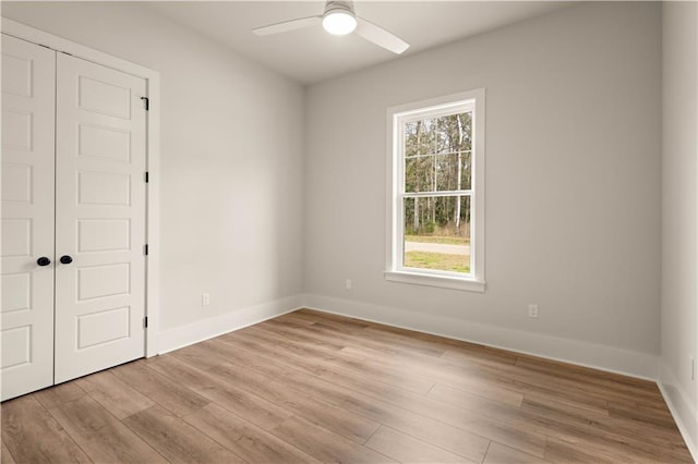 unfurnished room with light wood-style floors, ceiling fan, baseboards, and a wealth of natural light