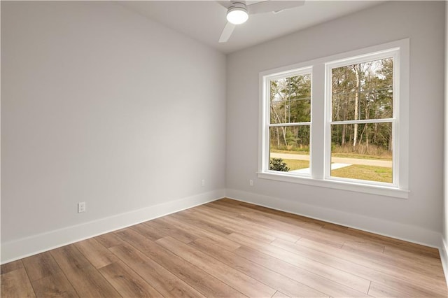 empty room featuring ceiling fan, light wood-style flooring, and baseboards