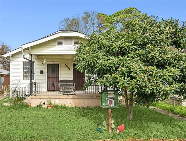 view of front of house featuring covered porch and a front lawn