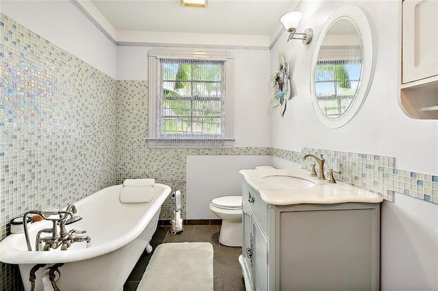 bathroom featuring tile walls, tile patterned flooring, vanity, toilet, and a bath