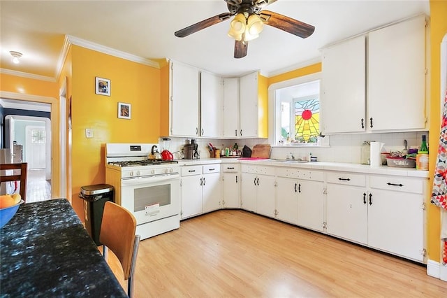 kitchen with white cabinetry, decorative backsplash, ornamental molding, white range with gas stovetop, and light hardwood / wood-style floors