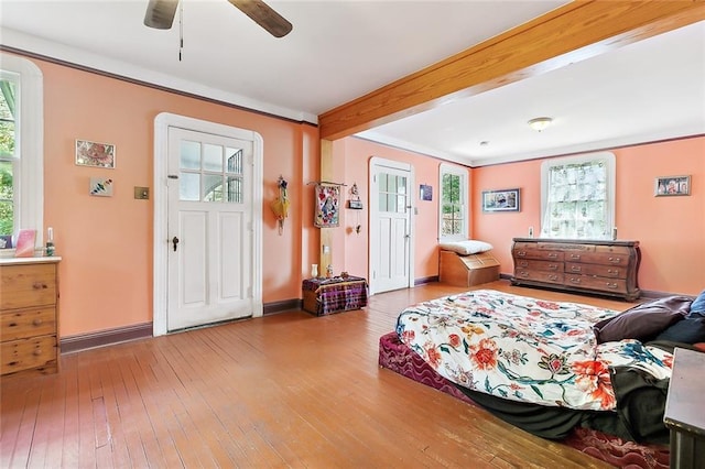 foyer entrance with ceiling fan, beamed ceiling, and light wood-type flooring