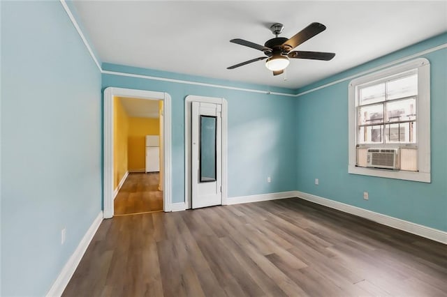 unfurnished bedroom featuring cooling unit, hardwood / wood-style flooring, ceiling fan, and white fridge