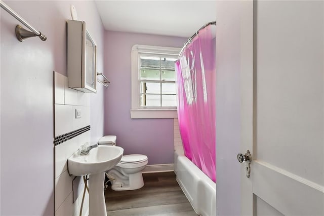 bathroom with hardwood / wood-style flooring, shower / bath combo, and toilet