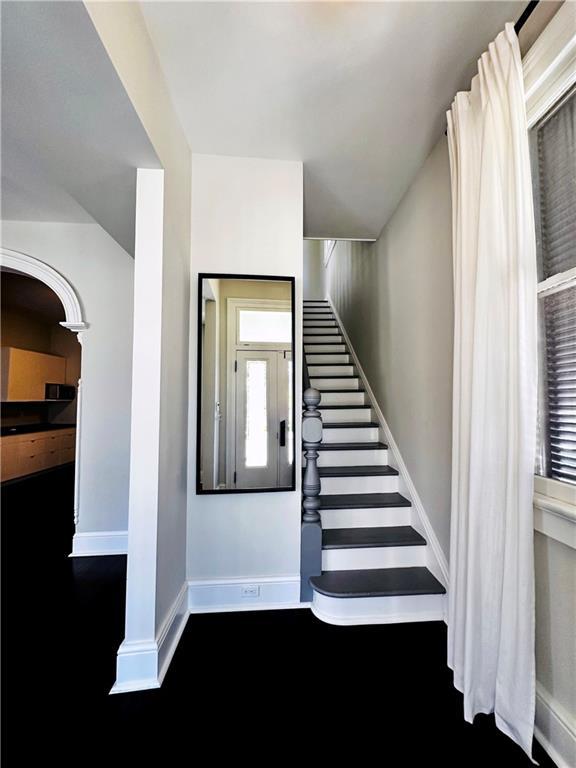 staircase featuring baseboards and wood finished floors