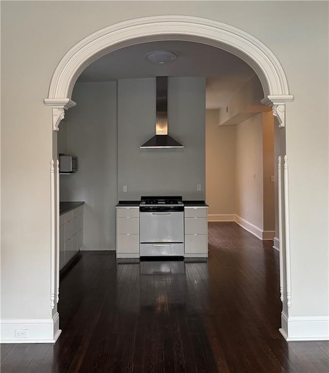 kitchen with dark wood-style flooring, white cabinetry, wall chimney range hood, range, and modern cabinets