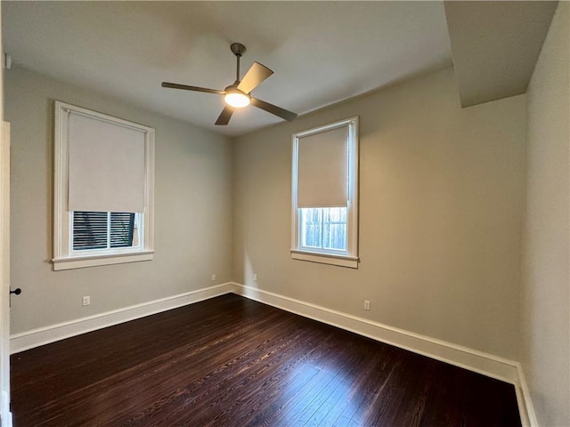 spare room featuring ceiling fan, baseboards, and dark wood-style flooring