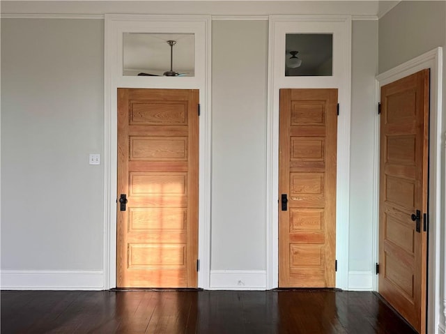 interior space with crown molding, baseboards, and wood finished floors