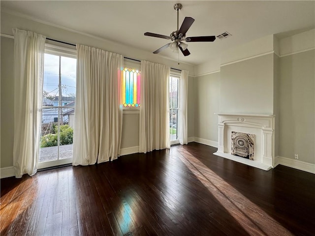 unfurnished living room with visible vents, a fireplace with flush hearth, a ceiling fan, wood-type flooring, and baseboards