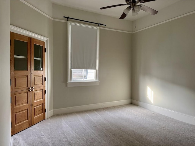 spare room with baseboards, a ceiling fan, a barn door, and carpet floors