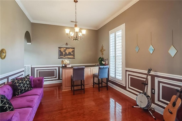 302 Charles Ct, Slidell, LA 70458 - dining space featuring dark wood-style floors, a chandelier, ornamental molding, arched walkways, and a wainscoted wall