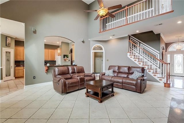 tiled living room featuring a high ceiling, crown molding, and ceiling fan