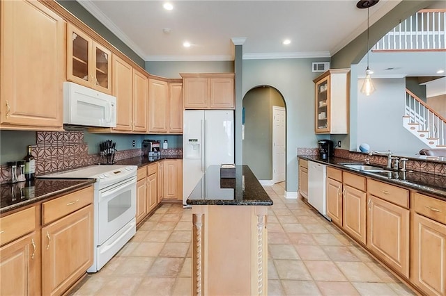 kitchen with light brown cabinetry, white appliances, and a center island