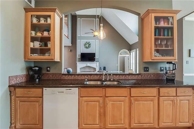 kitchen with vaulted ceiling, pendant lighting, dishwasher, sink, and dark stone counters