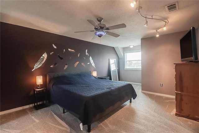 carpeted bedroom featuring ceiling fan and a textured ceiling