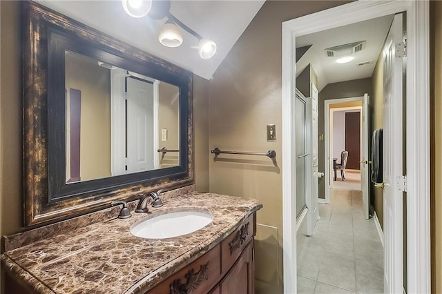 bathroom featuring a shower with door, vanity, and tile patterned flooring