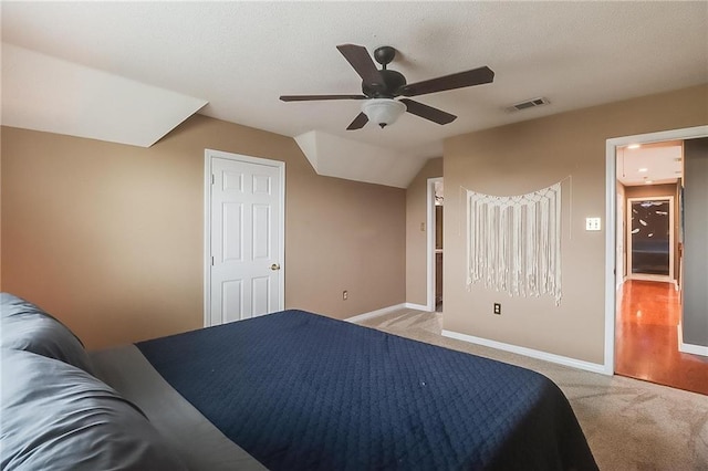 bedroom featuring ceiling fan, vaulted ceiling, and light carpet