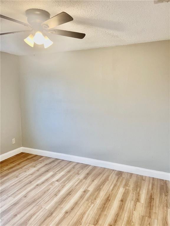 empty room featuring ceiling fan, light hardwood / wood-style floors, and a textured ceiling