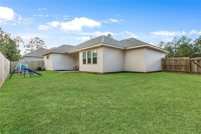 back of property with a playground, central AC, and a lawn