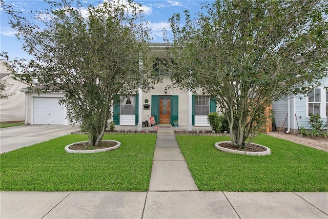 obstructed view of property featuring an attached garage, concrete driveway, brick siding, and a front yard