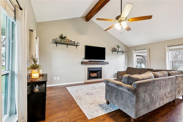 living room featuring dark wood-type flooring, ceiling fan, and vaulted ceiling with beams