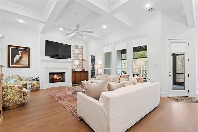 living room featuring hardwood / wood-style flooring, coffered ceiling, and beamed ceiling