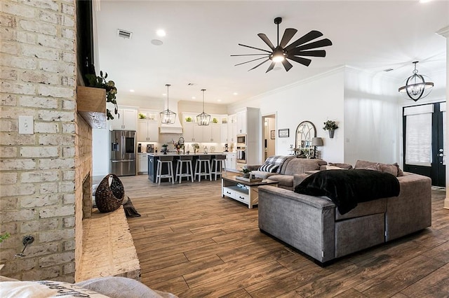 living room with crown molding, ceiling fan with notable chandelier, and dark hardwood / wood-style floors