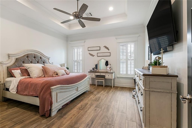 bedroom featuring ceiling fan, ornamental molding, a raised ceiling, and hardwood / wood-style floors