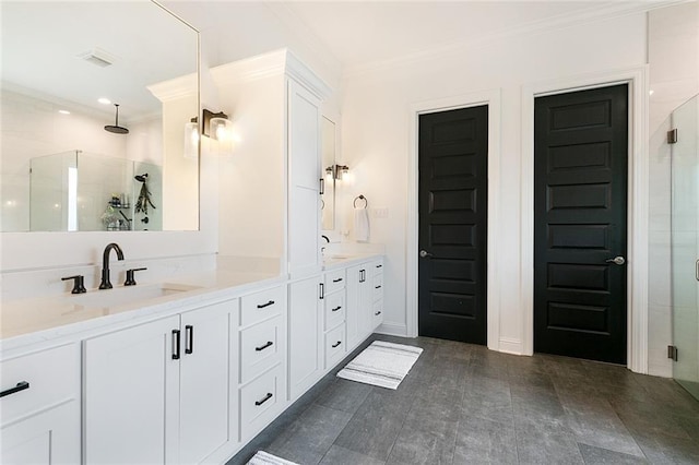 bathroom with vanity, a shower with shower door, and ornamental molding