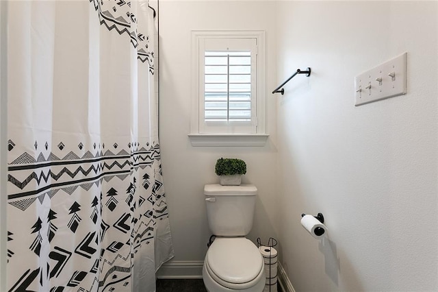 bathroom featuring walk in shower and toilet