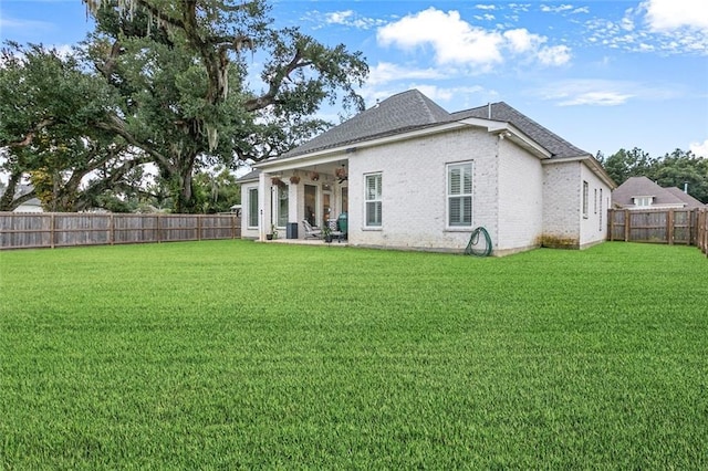 rear view of property featuring a lawn