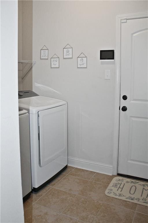 laundry room featuring washing machine and dryer and light tile patterned floors