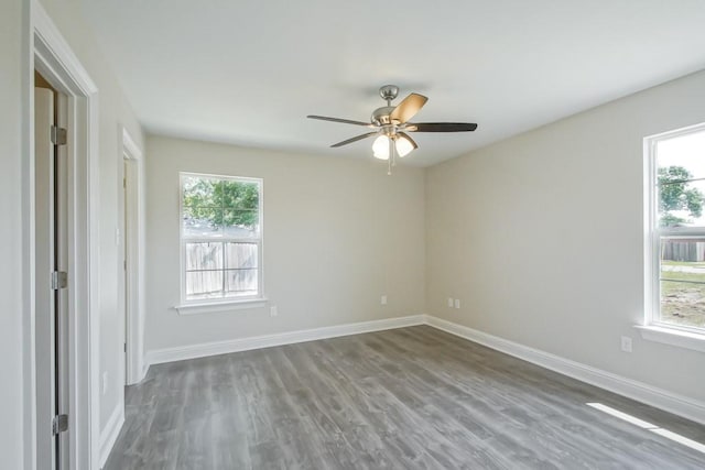 spare room with dark hardwood / wood-style flooring, plenty of natural light, and ceiling fan