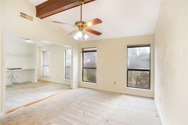 carpeted empty room with ceiling fan and lofted ceiling with beams