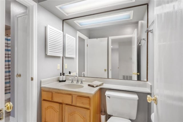 bathroom with vanity, curtained shower, and toilet