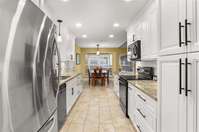 kitchen with pendant lighting, light stone countertops, black appliances, and white cabinets