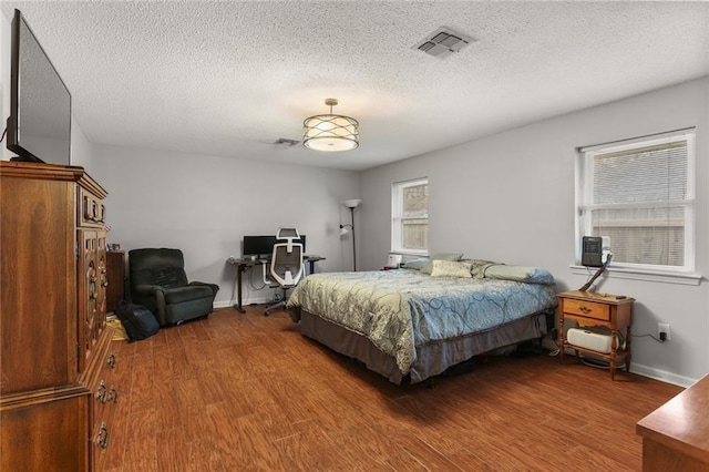 bedroom with hardwood / wood-style floors and a textured ceiling