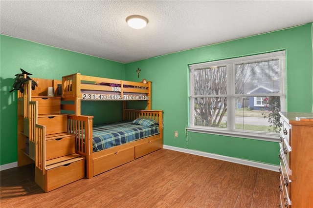 bedroom featuring light hardwood / wood-style floors and a textured ceiling