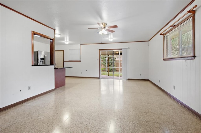 spare room with baseboards, ceiling fan, light speckled floor, and a healthy amount of sunlight