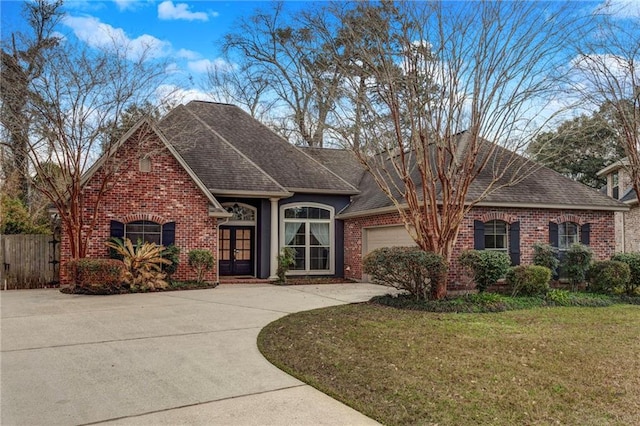 single story home featuring a garage, a front yard, and french doors