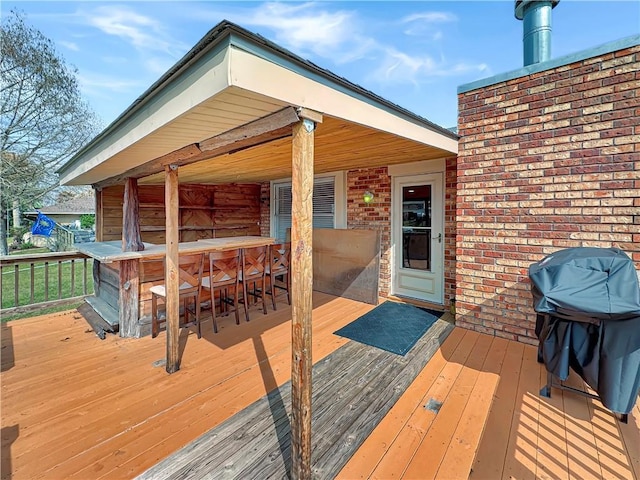 wooden deck featuring grilling area and exterior bar