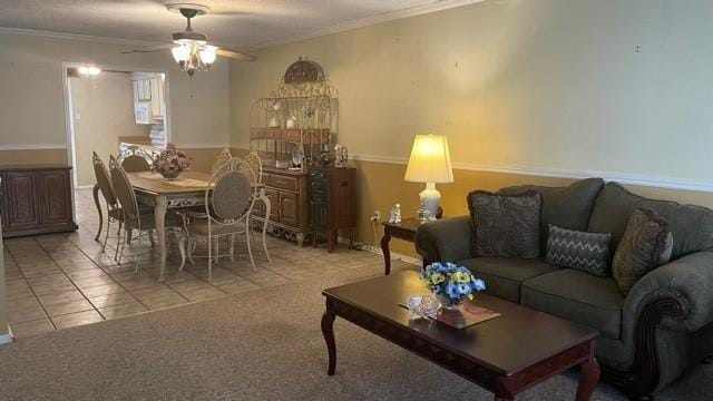 living room with crown molding, light tile patterned floors, and ceiling fan