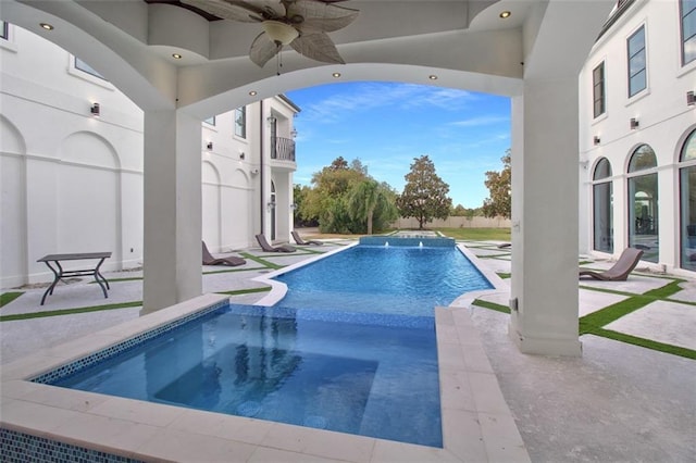 view of pool with a patio, a pool with connected hot tub, and a ceiling fan