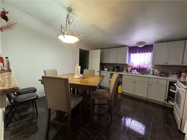 dining space featuring lofted ceiling, granite finish floor, a textured ceiling, and baseboards