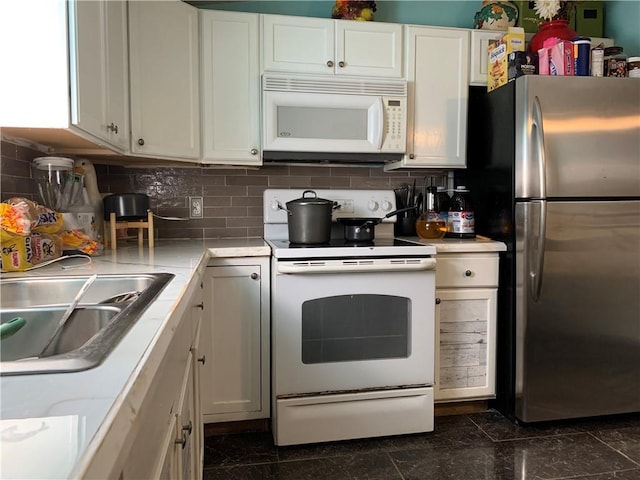 kitchen featuring light countertops, white appliances, and white cabinets