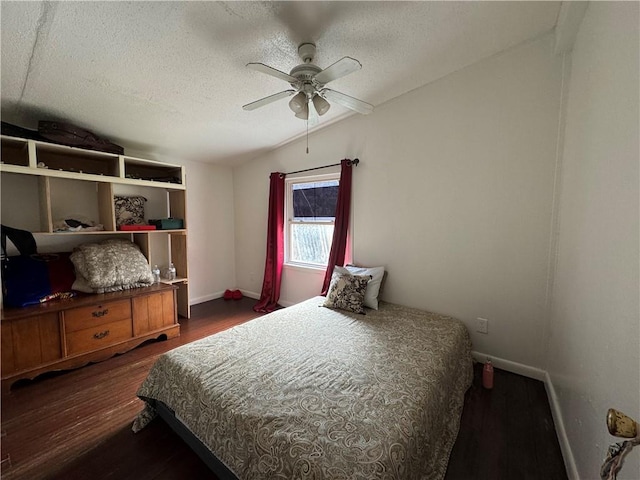 bedroom featuring lofted ceiling, a textured ceiling, dark wood-type flooring, a ceiling fan, and baseboards